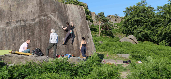 Three psychi boulderers climb a huge boulder at burbage south