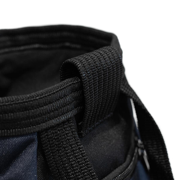 A Navy blue and black bouldering chalk bucket with drawstring closure and climbing accessory pockets