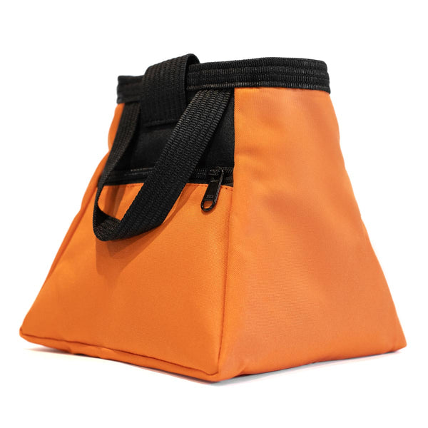 A light orange and black bouldering chalk bucket with drawstring closure and climbing accessory pockets