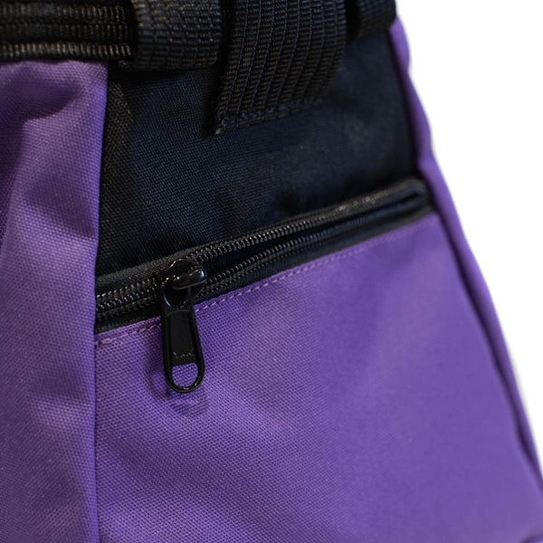 A purple and black bouldering chalk bucket with drawstring closure and zip closure climbing accessory pocket 