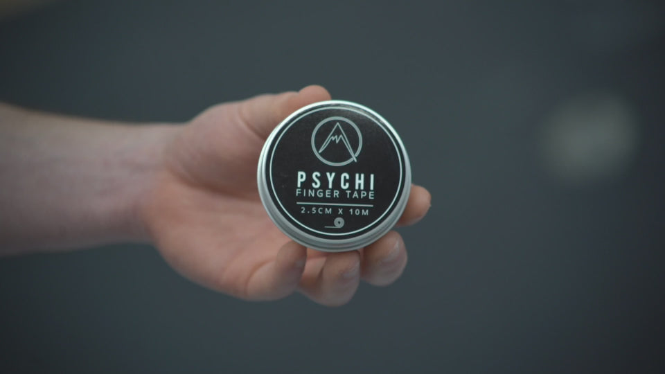 A climber unscrewing a tin containing cotton, zinc oxide finger tape and wrapping it around his fingers before ascending a route at rock over climbing centre in Manchester