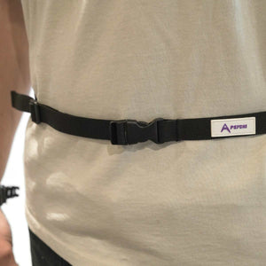 A climber wearing a black chalk bag strap around his waist