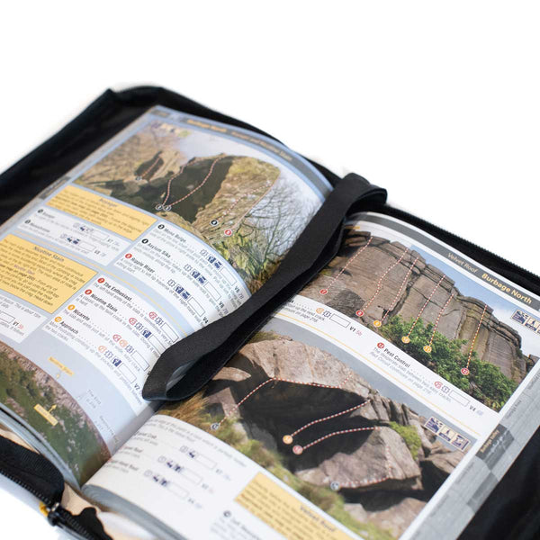 An open guidebook sits in a weatherproof protector case